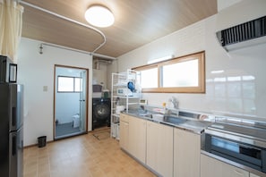 A modern kitchen with a built-in washer, a microwave, and a stainless steel oven.