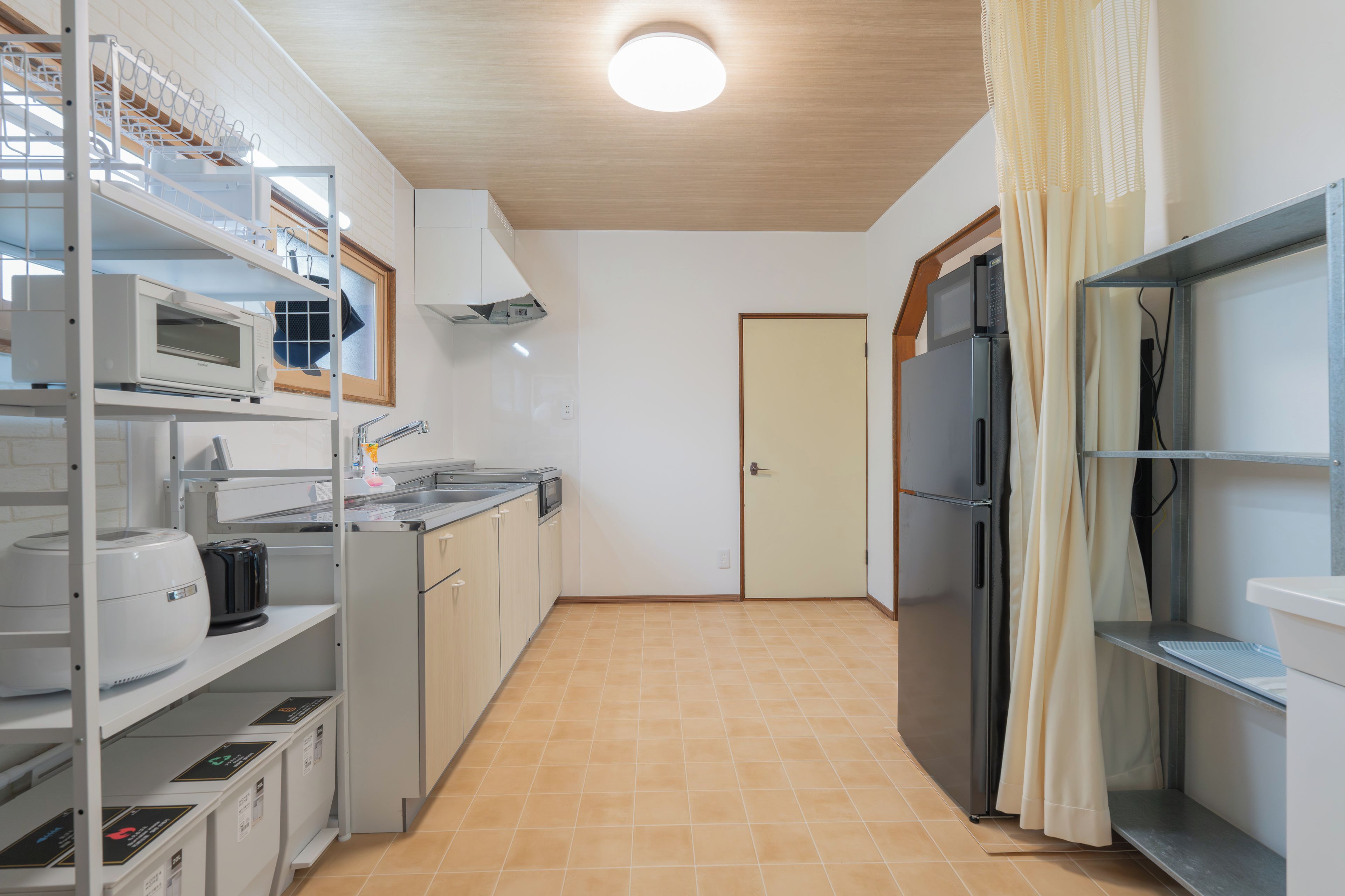 A compact kitchen with white cabinets, a microwave, a sink, and a refrigerator.