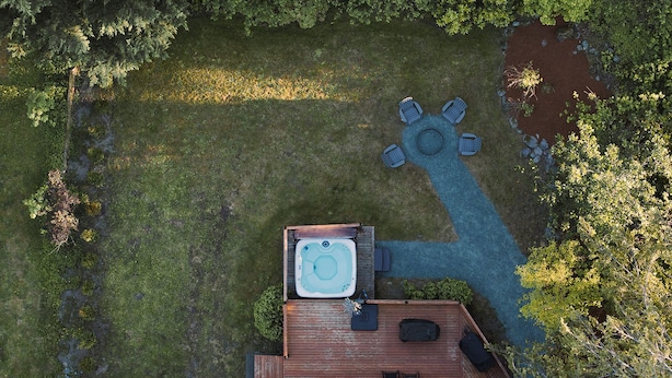 A rooftop patio with a hot tub, seating area, and a small deck. - Evergreen Escape •Hot Tub •Sauna •AC •Workspace! (Gold Bar)