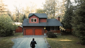 A two-story house with a red exterior and a covered porch. - Evergreen Escape •Hot Tub •Sauna •AC •Workspace! (Gold Bar)