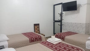 Una habitació d'hotel amb dos llits, un televisor penjat a la paret i un penjador.