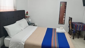 Habitació d'hotel amb un llit, una nit, una cadira i una taula.