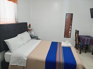 A hotel room with a bed, a nightstand, a chair, and a table. - Casa del Valle (Cusco)