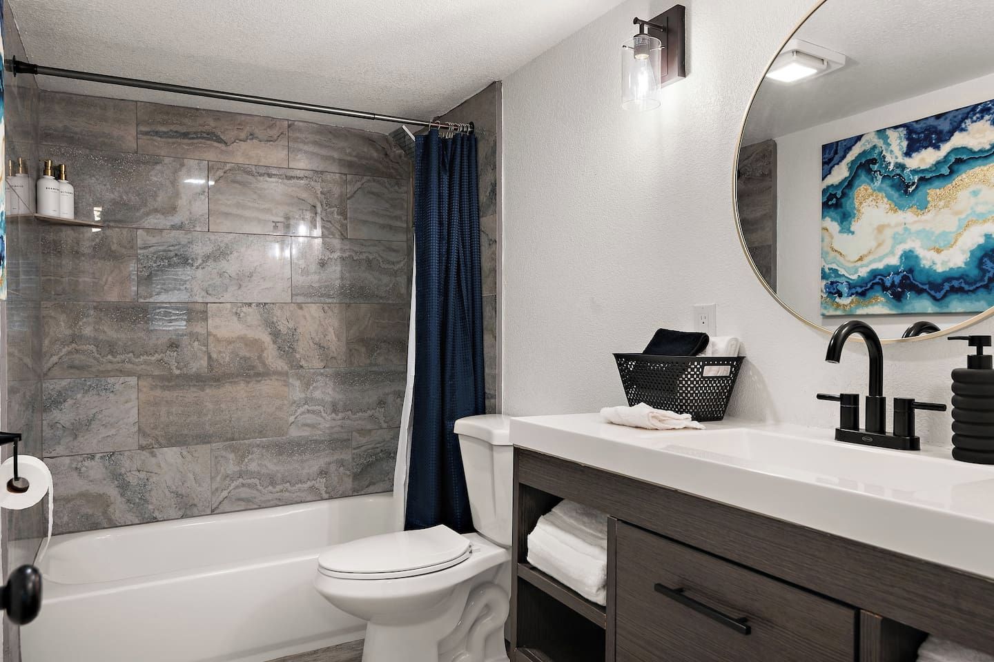 Une salle de bain équipée d’une baignoire, de toilettes et d’un meuble-lavabo avec un miroir et un évier.