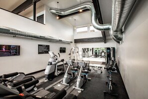 Ein Fitnessstudio mit unterschiedlichen Trainingsgeräten, darunter Laufbänder und Kraftgeräte.