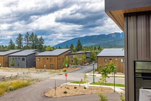 Un ensemble immobilier moderne composé de plusieurs bâtiments, avec un ciel dégagé et un paysage montagneux en arrière-plan.