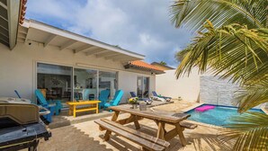 Un pati amb piscina, mobles d'exterior i una barbacoa.