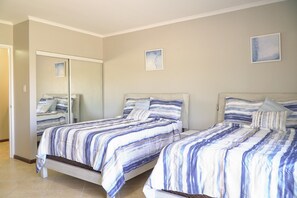 A bedroom with two beds, a large mirror, and two framed pictures on the wall. - Private HotTub Escape:ModernLuxe Townhome 2BR3BA (Noord)