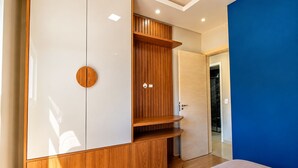 Ein modernes Schlafzimmer mit Kleiderschrank, Bett und einer blauen Wand.