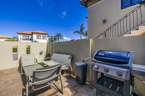 An outdoor patio with a barbecue grill, a table, and chairs. - Private Pool Paradise: Luxe Resort Living (Noord)
