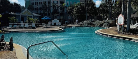 Una piscina con zona de piscina, sillas de descanso y un cartel con las normas de la piscina.