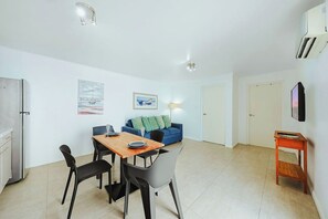 Ein stilvolles Wohnzimmer mit Essbereich, einer Couch und einem kleinen Tisch.