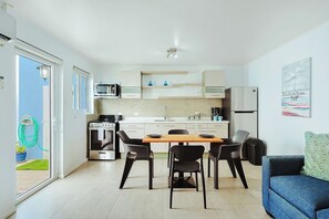 Eine moderne Küche mit Essbereich, einer Couch und einem Gemälde an der Wand.