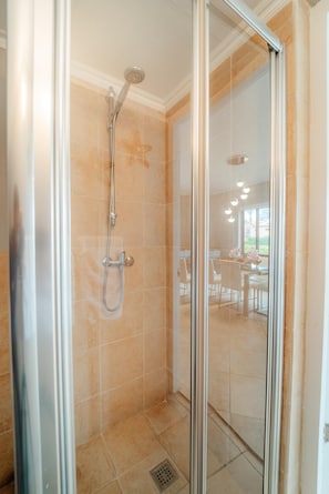 A glass-enclosed shower with a handheld showerhead and a wall-mounted faucet. - Villa Diamante: Luxe Oasis, Gold Coast 4BR 3BA (Noord)