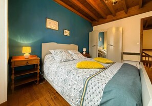 Ein Schlafzimmer mit einem Bett, einem Nachttisch, einer Lampe und einem Spiegel.