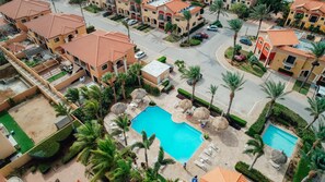 A residential area with multiple apartment buildings, a central swimming pool, and surrounding greenery. - 4BR Townhome-Private Hot Tub & Gazebo w/ Pool, Gym (Noord)