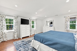 A bedroom with a bed, a dresser, a television, and a mirror. - Paws on Murphy - Near Beaches & Main Street (Hyannis)