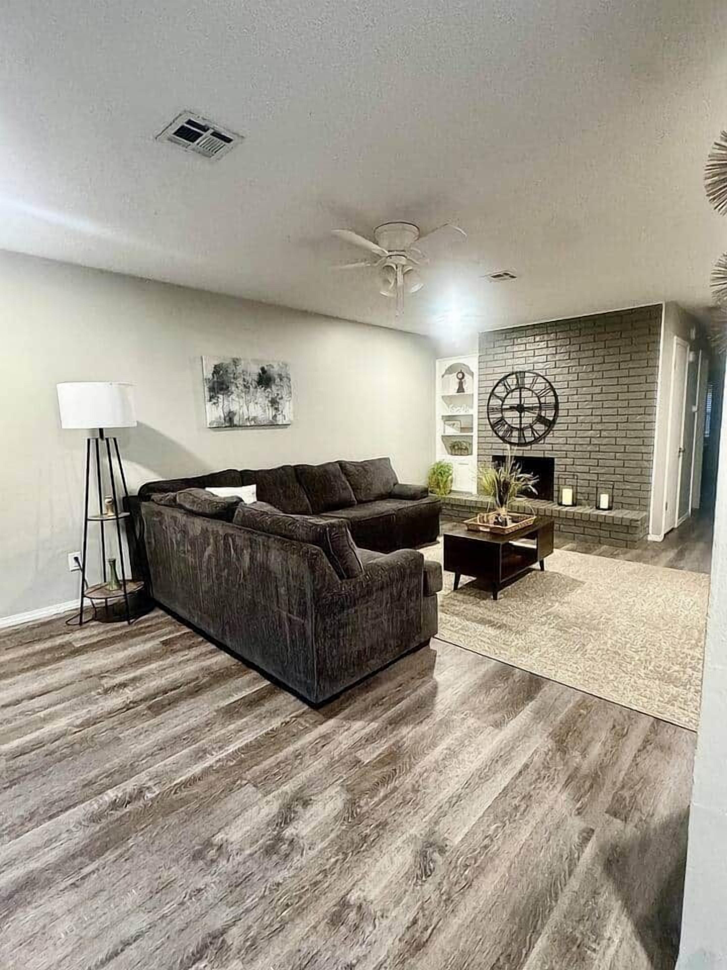 A modern living room with a sectional sofa, a coffee table, and a fireplace.