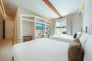Ein Hotelzimmer mit einem großen Bett, einem Fernseher, einem Balkon mit Blick und einem Holzbalken an der Decke.
