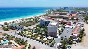 A coastal resort with multiple buildings, a beach, and a swimming pool. - LeVent Sanctuary: Luxe Eagle Beach Condo 3BR 2BA (Eagle Beach)