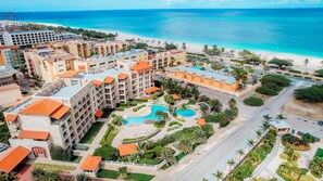 Ein Resort mit mehreren Gebäuden, einem Poolbereich und einem Strand.