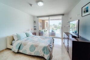 Une chambre à coucher avec un lit, une télévision et une vue sur l’extérieur.