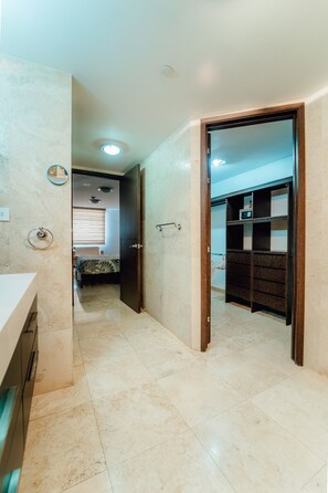 Ein Flur mit Badezimmer, Bett und Kleiderschrank.