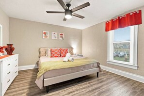 A bedroom with a bed, a nightstand, a dresser, a ceiling fan, and a window with blinds. - Beautifully Remodeled 3BR Home Near Niagara Falls! (Niagara Falls)