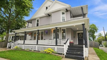 A two-story house with a front porch, a covered entryway, and a visible front yard.