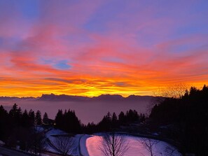 Eine gebirgige Landschaft mit einem Fluss und schneebedecktem Boden.