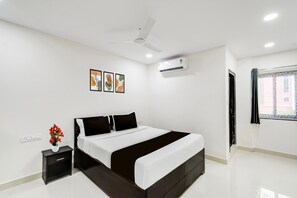 A modern bedroom with a bed, bedside table, wall-mounted air conditioning, ceiling fan, and a window with curtains. - Townhouse Near Narsingi Manikonda (Hyderabad)