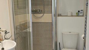 A bathroom with a glass-enclosed shower, a white sink, and a toilet. - House Sleeps 4 with Parking (Newquay)