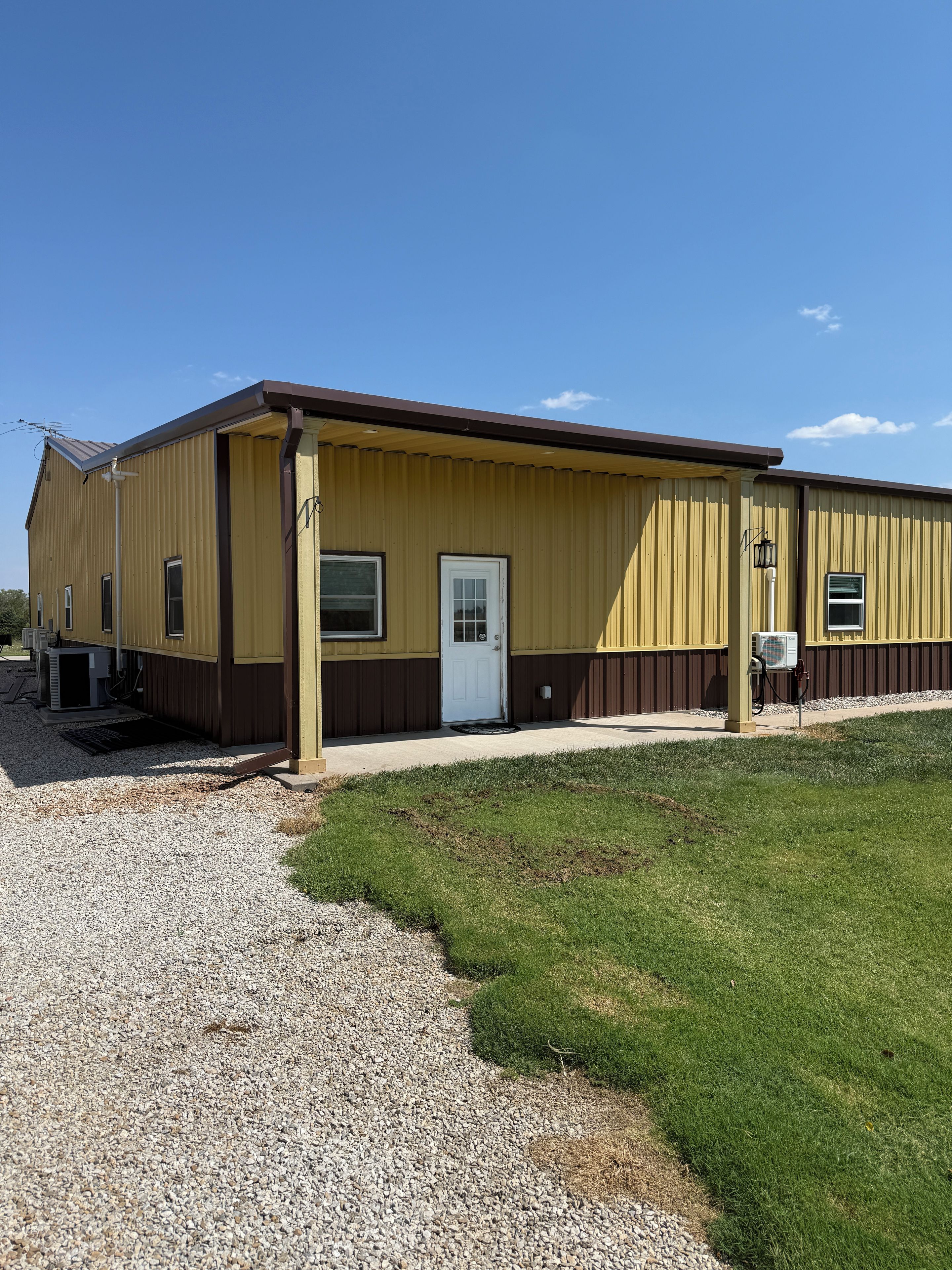 Un bâtiment d’un seul étage, doté d’un toit plat, d’une porte d’entrée et d’un petit porche.