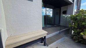 A bench outside a building with a glass door and a small plant beside it. - Stunning Plymouth Harbour Views|Close to Historic Barbican|3 Bedroom House of Stylish Design (Plymouth)