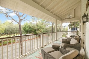 A covered porch with wicker furniture and a view of the surrounding landscape. - Phase 1 WaterColor, EZ Walk to Beach Club! 2 Bikes (Santa Rosa Beach)