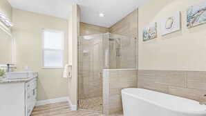 A modern bathroom with a glass-enclosed shower, a white bathtub, and a vanity with a sink. - Your Waterfront Escape | Pool, Spa & Firelight (Cape Coral)