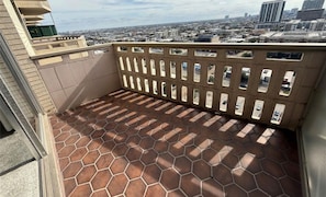A balcony with a tiled floor and a metal railing.