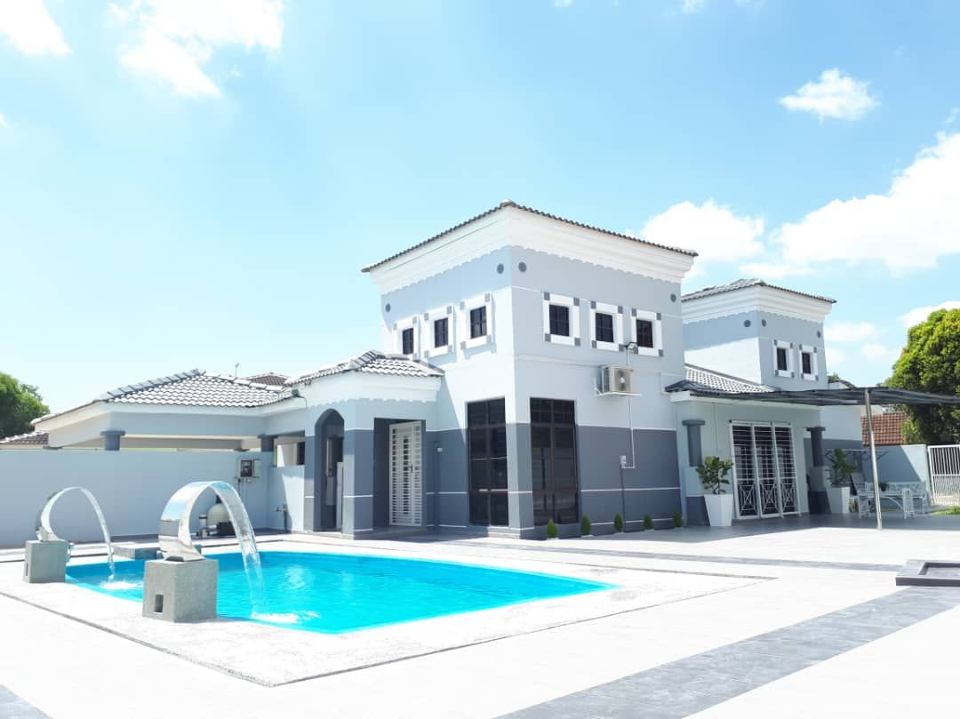 Ein modernes, zweistöckiges Haus mit Swimmingpool, überdachter Terrasse und Garage.