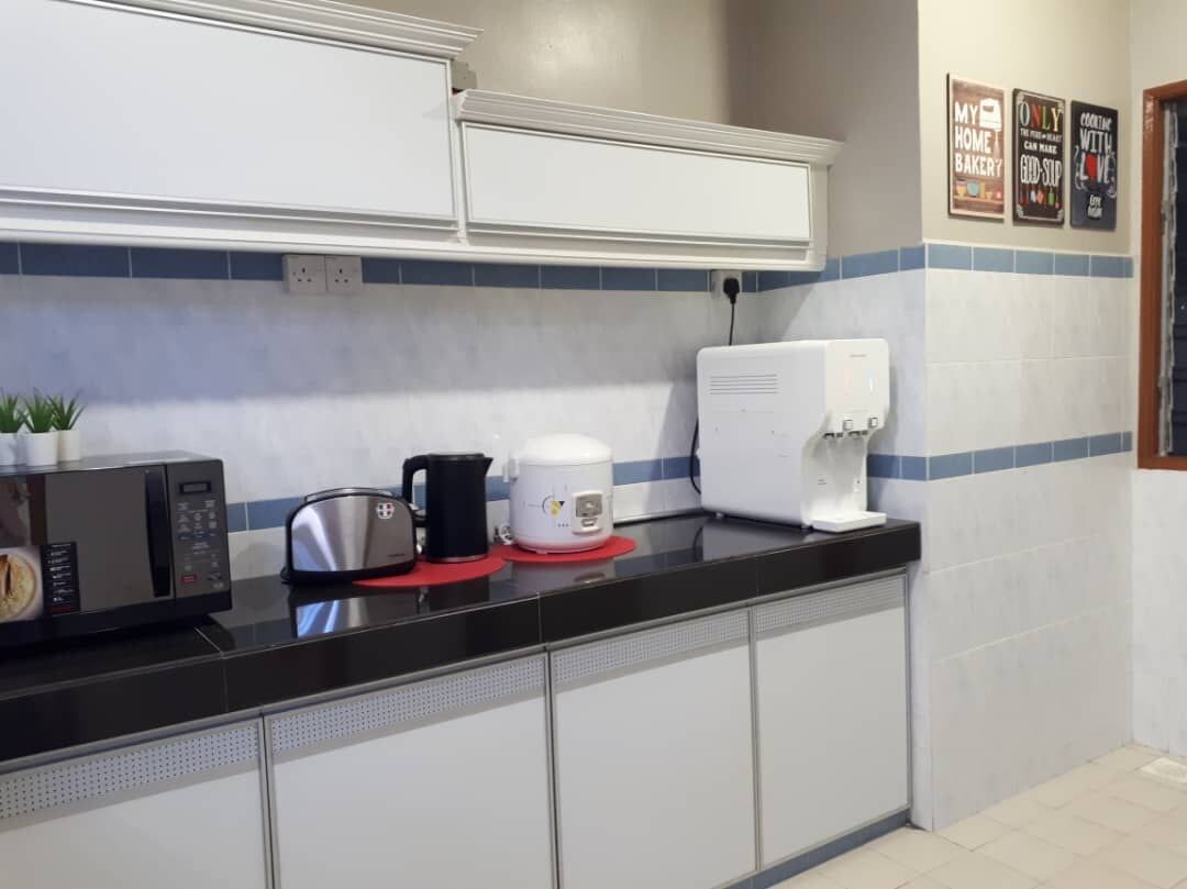 Une cuisine équipée d’un four à micro-ondes, d’un grille-pain et d’une machine à café, le tout posé sur le plan de travail.