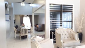 A modern living room with a sofa, dining chairs, and a ceiling fan. - Melaka A’Famosa Grand Pool Villa – Private Pool & Family Getaway (Alor Gajah)