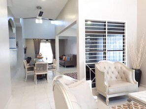 A modern living room with a sofa, dining chairs, and a ceiling fan. - Melaka A’Famosa Grand Pool Villa – Private Pool & Family Getaway (Alor Gajah)