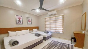 A hotel room with two beds, a ceiling fan, an air conditioning unit, a window with blinds, and a small desk with a mirror. - Melaka A’Famosa Grand Pool Villa – Private Pool & Family Getaway (Alor Gajah)