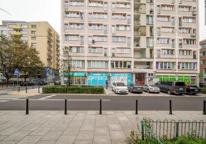A multi-story residential building with balconies and a ground-level commercial establishment. - City Center Śliska Apartment (Warszawa)