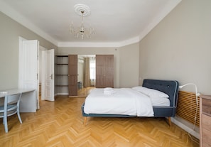 Een slaapkamer met een bed, een bureau en een kledingkast.