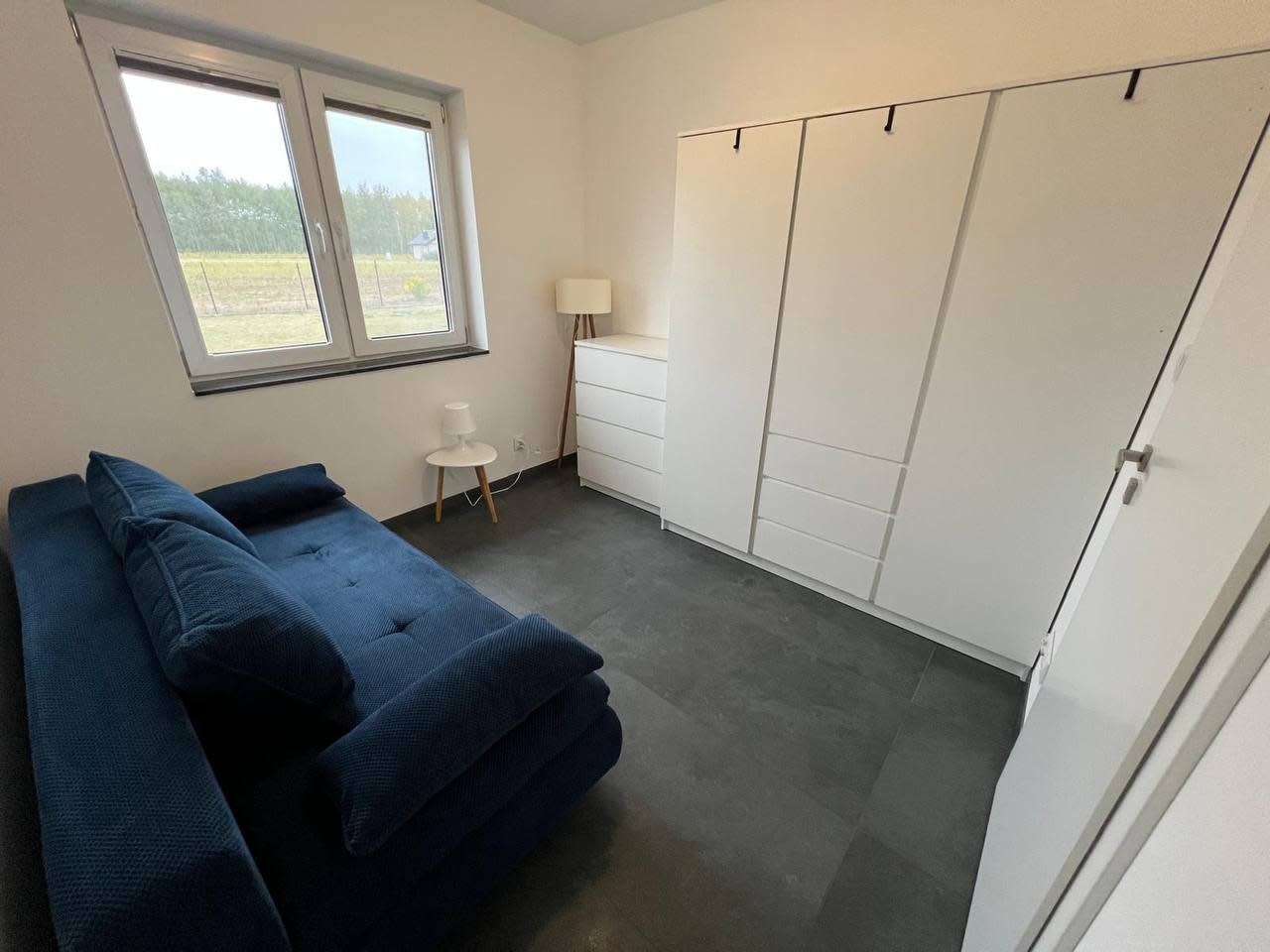A room with a bed, a desk, a chair, and a wardrobe.