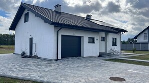 Et moderne hus med to etager, garage, belagt indkørsel og en lille have.