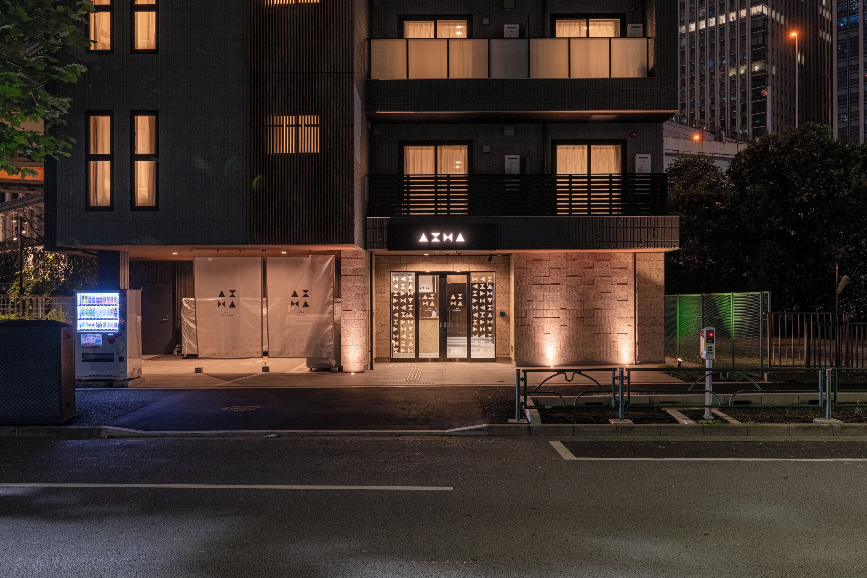 A modern building with a storefront labeled 'AIMA'.