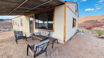 Una pequeña construcción con un porche techado, una ventana y una puerta.