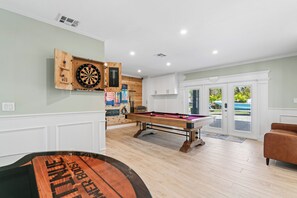 A billiards room with a pool table, a dartboard, and a dartboard cabinet. - Waterfront 4BR + deep water+ 2 Docks + Outdoor Kitchen, Sleeps 11 (Ruskin)