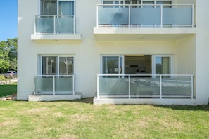 Ein modernes, zweistöckiges Gebäude mit Balkonen, großen Fenstern und einem sichtbaren Küchenbereich.